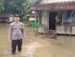Anggota Polsek Paloh Monitoring Banjir Rob Pasang Air Laut yang Masih Merendam Rumah Warga