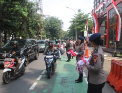 Brimob Metro Jaya Bagikan 5.000 Bendera Merah Putih kepada Warga Jakarta Jelang Hari Kemerdekaan RI