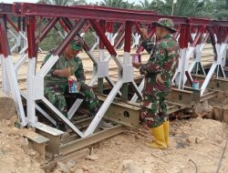Anggota Koramil 13/Baktiya Fokus Lanjutkan Pengecatan Jembatan Belly Penghubung Dua Desa